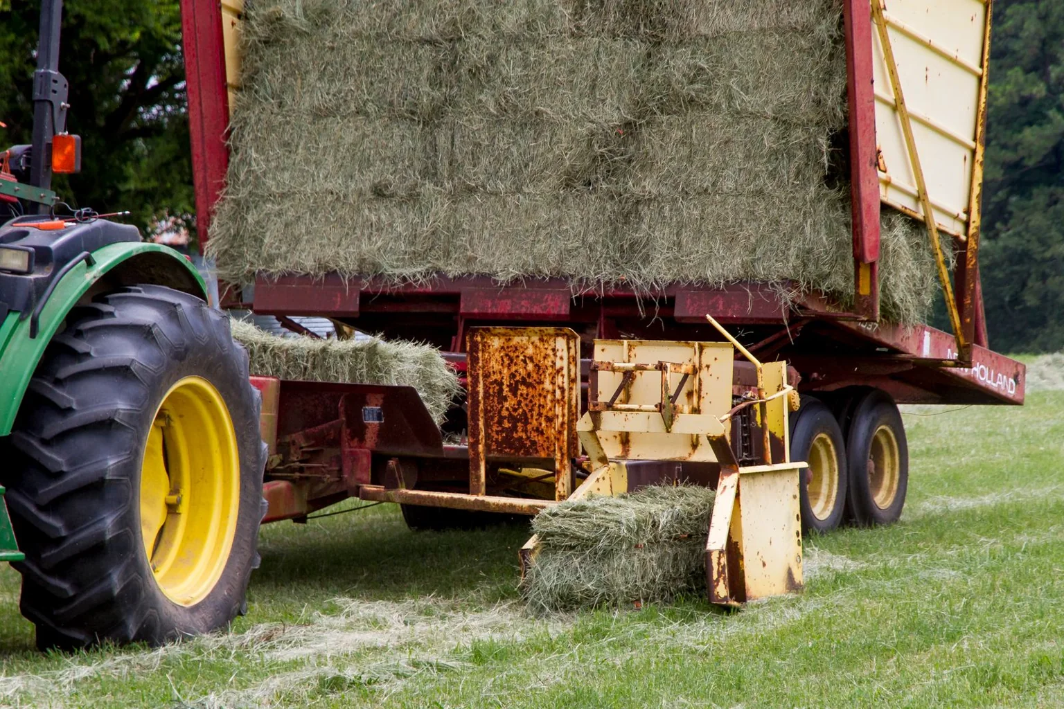 A square baler producing rectangular hay bales in a field